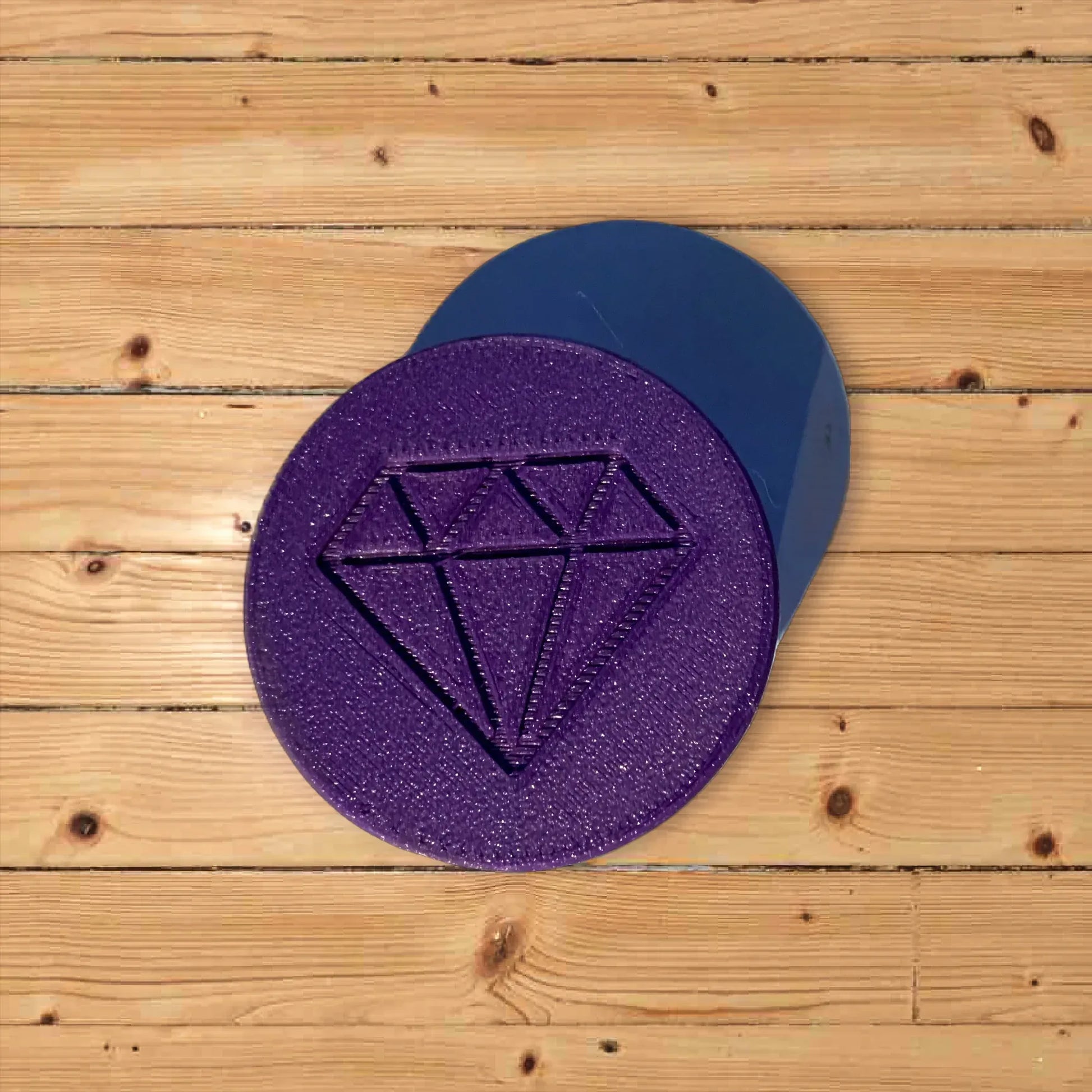 Grinder circulaire violet scintillant avec motif diamant, empilé avec le capuchon bleu.