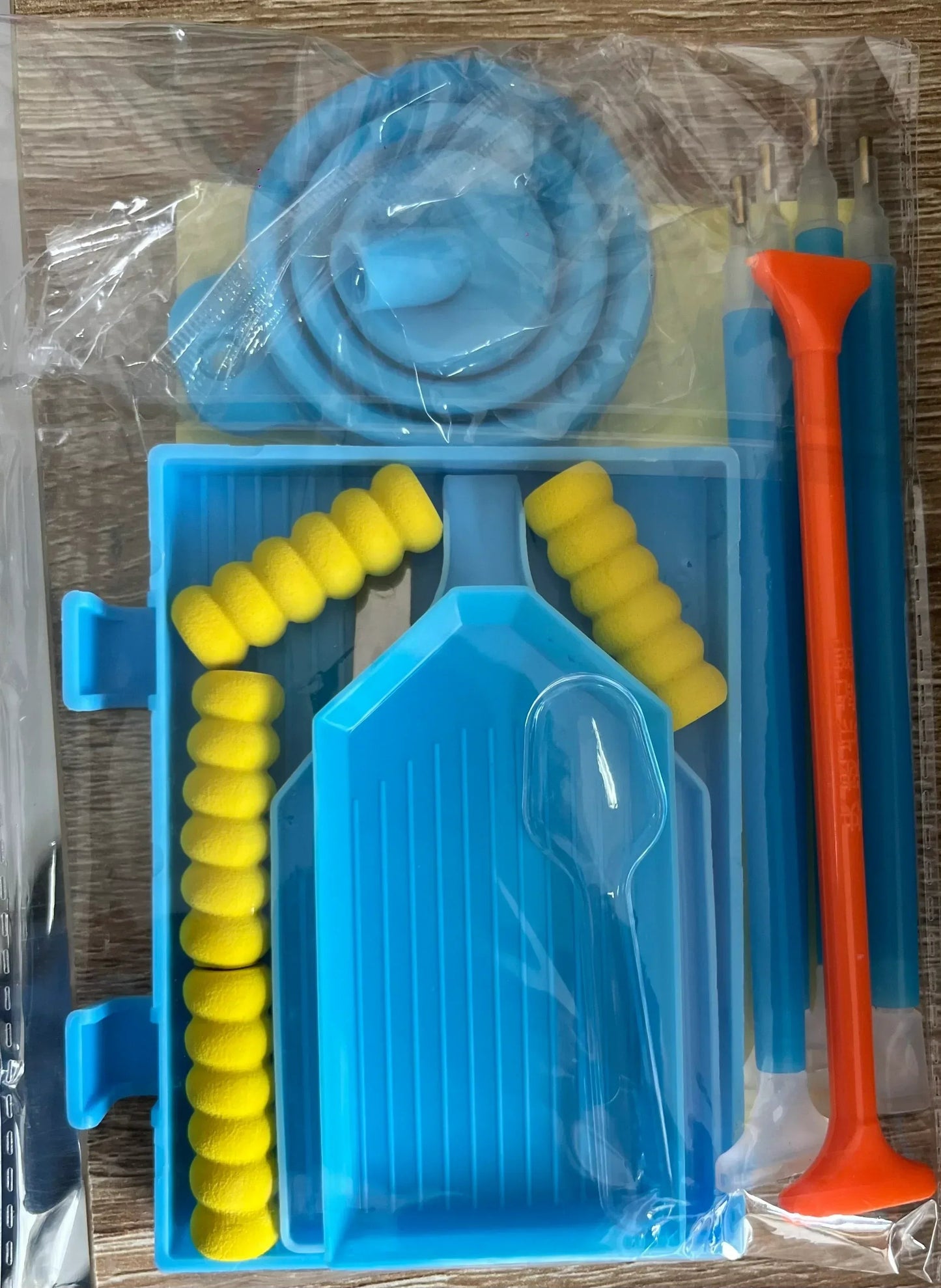 Valise de rangement avec plateau bleu, rouleaux jaunes et outil orange, en sachet